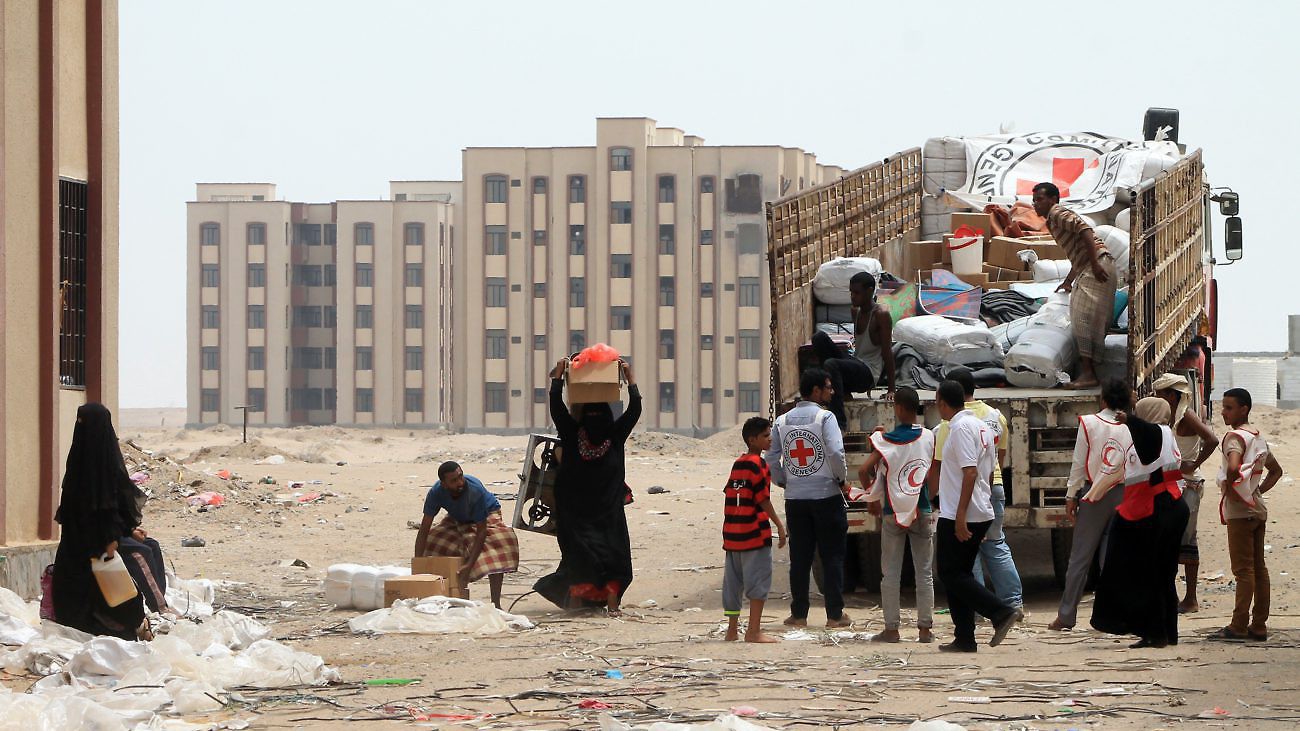 Members of the Yemeni Red Crescent distribute aid to displaced families in the al-Saleh neighbourhood north of the southern Yemeni city of Aden on June 22, 2015 as coalition air strikes continue to target rebel positions and clashes between rebels and pro-government forces riddle the city. AFP PHOTO / SALEH AL-OBEIDI        (Photo credit should read SALEH AL-OBEIDI/AFP/Getty Images)